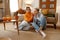 Happy lgbt woman couple eating taste snacks while sitting at home living room