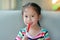 Happy little Asian child girl feeding liquid medicine with a syringe by self