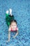 Happy little Asian child girl in a mermaid suit lying poolside with looking camera