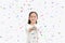 Happy little Asian child girl shooting party popper confetti over white background