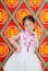 Happy little Asian child girl wearing pink Traditional cheongsam dress for Chinese New Year celebration on chinese background