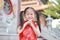 Happy little Asian child girl wearing red cheongsam with greeting gesture celebration for Chinese New Year at chinese temple in