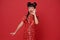 Happy Little asian child wearing traditional cheongsam qipao dress shout announcement Happy Chinese new year 2024 isolated on red