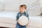 Happy little baby boy with ball at home