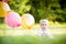 Happy little blonde caucasian girl outside with balloons