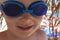 Happy little boy with blue diving glasses and grains of sand on