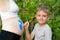 Happy little boy draws with a brush on the belly of his pregnant mom babyâ€™s footprint. Pregnant concept. Close-up