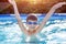 Happy little boy in goggles enjoying play in pool