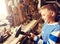 Happy little boy with hammer and plank at workshop