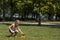 Happy little boy play in water drops from irrigation system, heat in the city