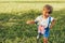 Happy little boy playing with a binoculars searching for an imagination or exploration in summer day in park. Active child playing