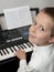 Happy little boy playing keyborad piano