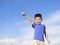 Happy little boy pointing direction with blue sky