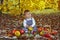 Happy little boy with pumpkins ,apples ,pears in autumn park