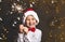 Happy little boy in santa claus hat holding sparkler. Christmas Eve