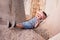 Happy little boy in singlet and shorts lies on a concrete breakwater closing his eyes with hand