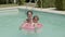 Happy little boy sitting on inflatable tube in swimming pool