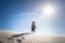 Happy little boy standing at top of windy sand dune on a late summer afternoon