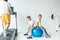 happy little boys sitting on fitness ball while father exercising
