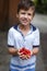 Happy little caucasian boy holding cherries in hands