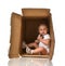 Happy little child baby girl hiding in a cardboard box having fu