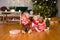 Happy little children in pajamas playing with Christmas presents - beautiful boxes and car. Family Xmas morning in decorated