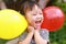 Happy little cute lovely girl Chinese child smile laugh play colorful balloon have fun at summer park nature happiness childhood