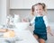 Happy little girl baking alone. Caucasian child baking in her kitchen. Portrait of a young girl mixing a bowl of batter