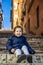 An happy little girl Caucasian smiles and enjoys sitting on a step