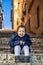 An happy little girl Caucasian smiles and enjoys sitting on a step