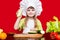 Happy little girl in chef uniform cuts vegetables in kitchen. Kid chef