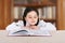 Happy little girl child reads book in library