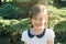 Happy little girl with closed eyes in spray of thermal water drops on hot summer day in the park