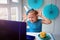 A happy little girl, crooked  in front of a laptop celebrates a birthday via the internet in quarantine time, self-isolation,