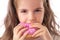 Happy little girl eating pink donut