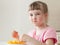 Happy little girl eating a tasty orange