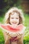 Happy little girl eating watermelon in summer park. Instagram filter.