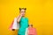 Happy little girl with funny tails standing  over yellow background holding shopping bags. Looking camera