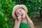 Happy little girl gardener eating fresh cucumber