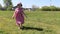 Happy little girl goes on green grass at sunny summer day