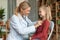 Happy little girl having checkup at pediatrician, child smiling while doctor checking up her chest with stethoscope