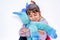 Happy little girl holding blue unicorn toy isolated on white