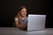 Happy little girl infront of the laptop typing isolated.