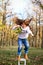 Happy little girl jumping from chair outdoors