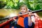 Happy little girl on a kayak on a river