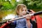 Happy little girl on a kayak on a river