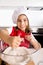 Happy little girl learning baking mixing flour in bowl wearing red apron and cook hat smiling satisfied