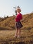 Happy little girl with long hair portrait jumping on nature background windy day. Cute kid walking alone in autumn park