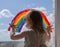 A happy little girl looks out the window with a painted rainbow. everything will be alright. a girl draws a rainbow on the window.