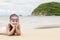 Happy little girl lying on the sand on the beach Female preschooler kid